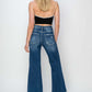 Woman wearing Risen Jeans high rise patch detailed wide leg crop jeans, viewed from the back, showcasing trendy denim style.