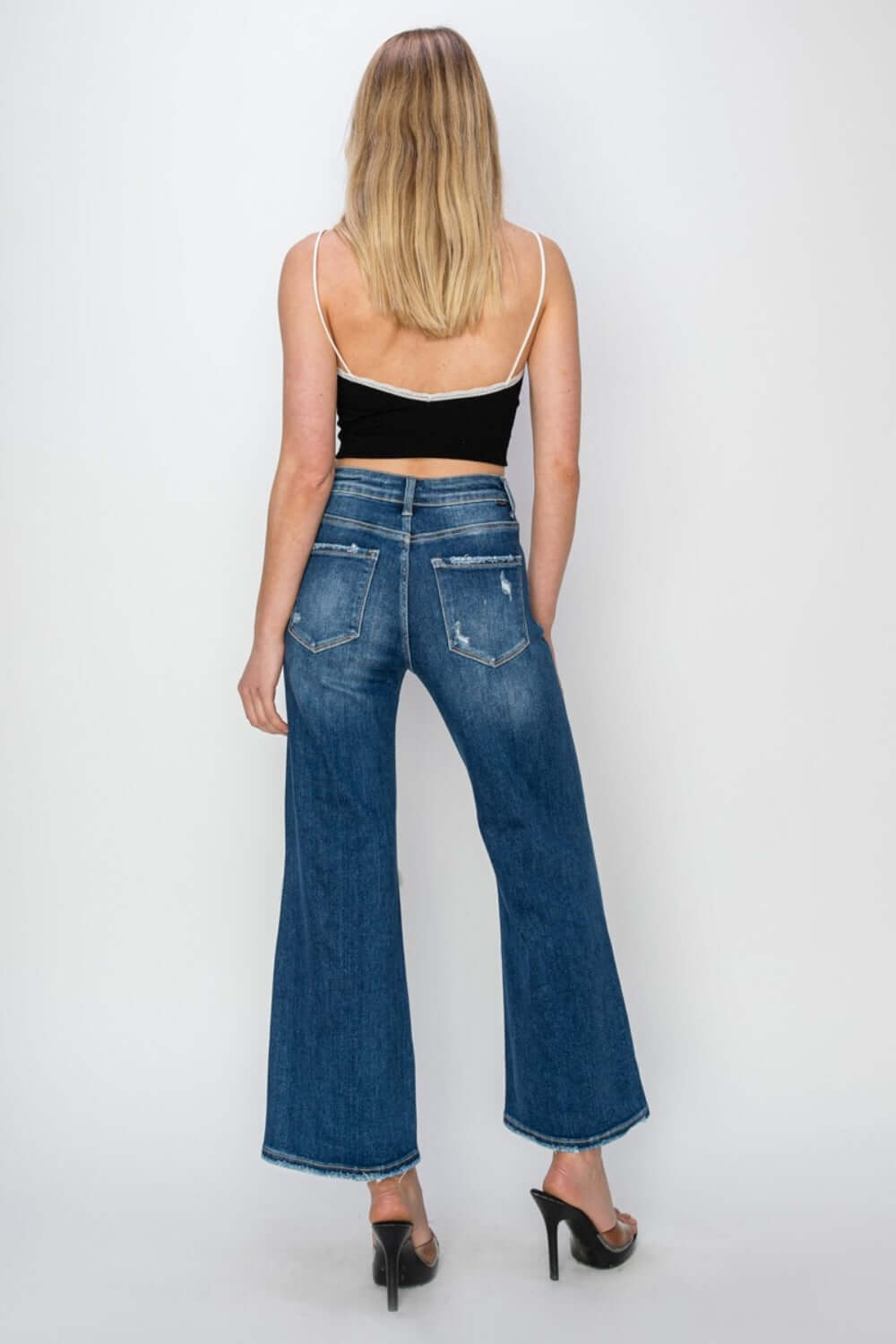 Woman wearing Risen Jeans high rise patch detailed wide leg crop jeans, viewed from the back, showcasing trendy denim style.