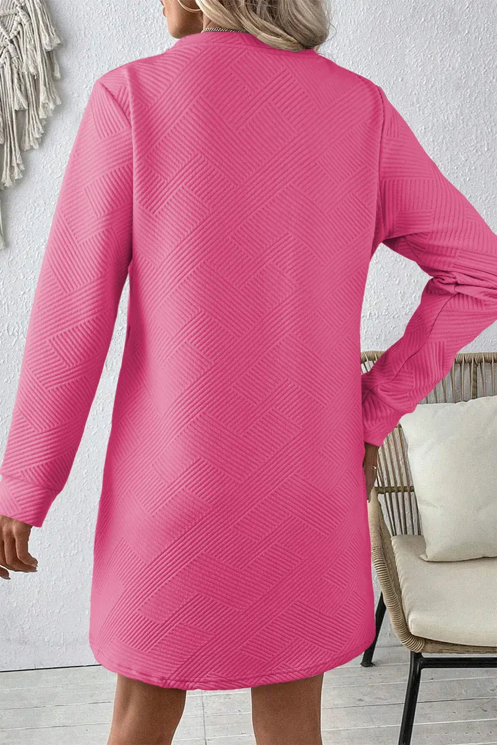 Back view of Bella Road pink textured long sleeve mini dress, showcasing its stylish design and comfortable fit.