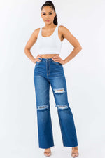 High Waist Distressed Wide Leg Jeans with button waist closure and distressed trims, styled with a white crop top and heels.