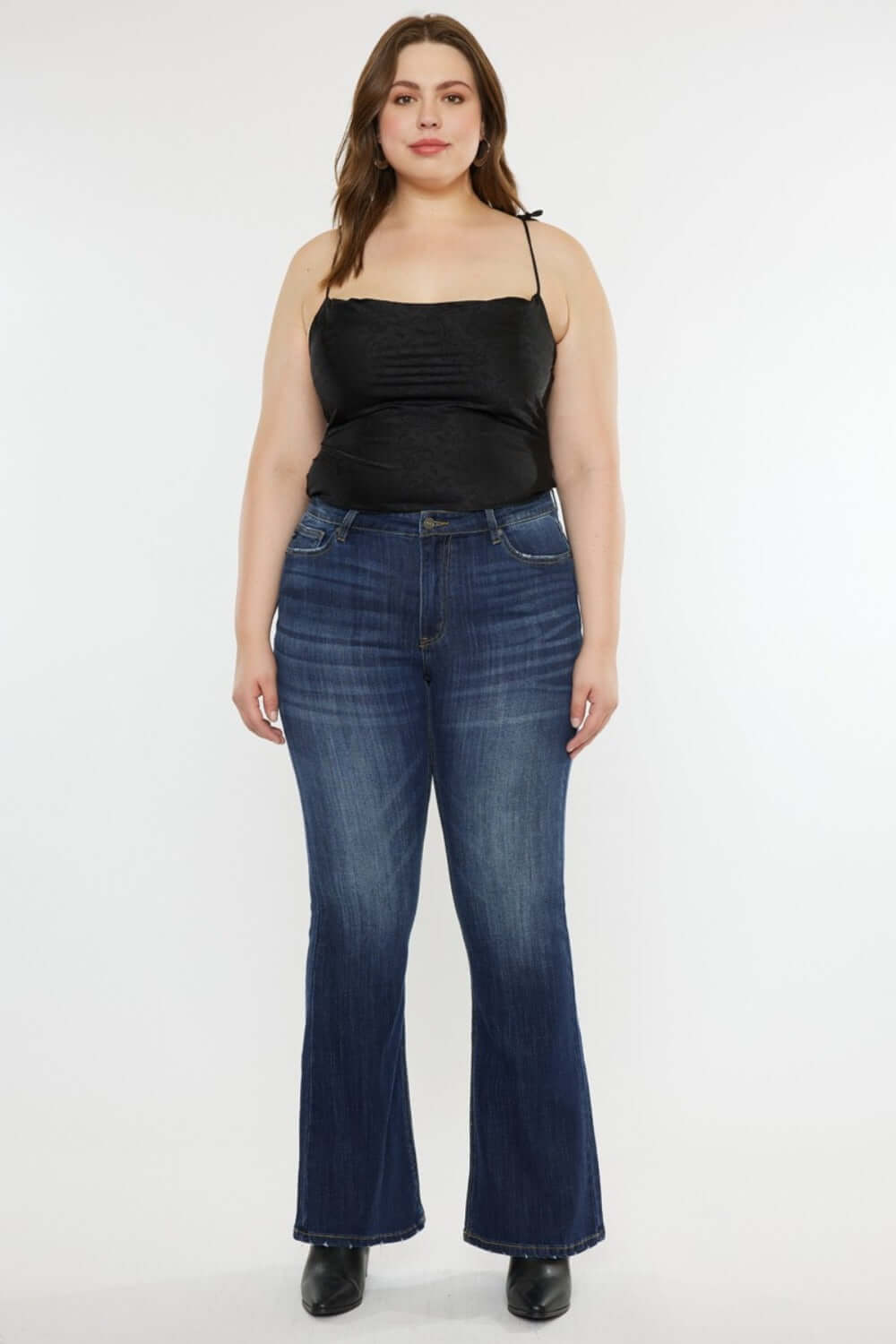 Woman wearing Kancan mid-rise slim flare jeans in dark stone wash, showcasing a flattering silhouette and versatile style.