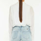 High Rise Side Slit Denim Shorts featuring a high-waist and back view on a model, paired with a white shirt.