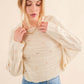 Woman wearing cozy Dolman Sleeves Sweater in cream, paired with blue jeans. Perfect for cooler months, offering a relaxed, trendy, and versatile look.