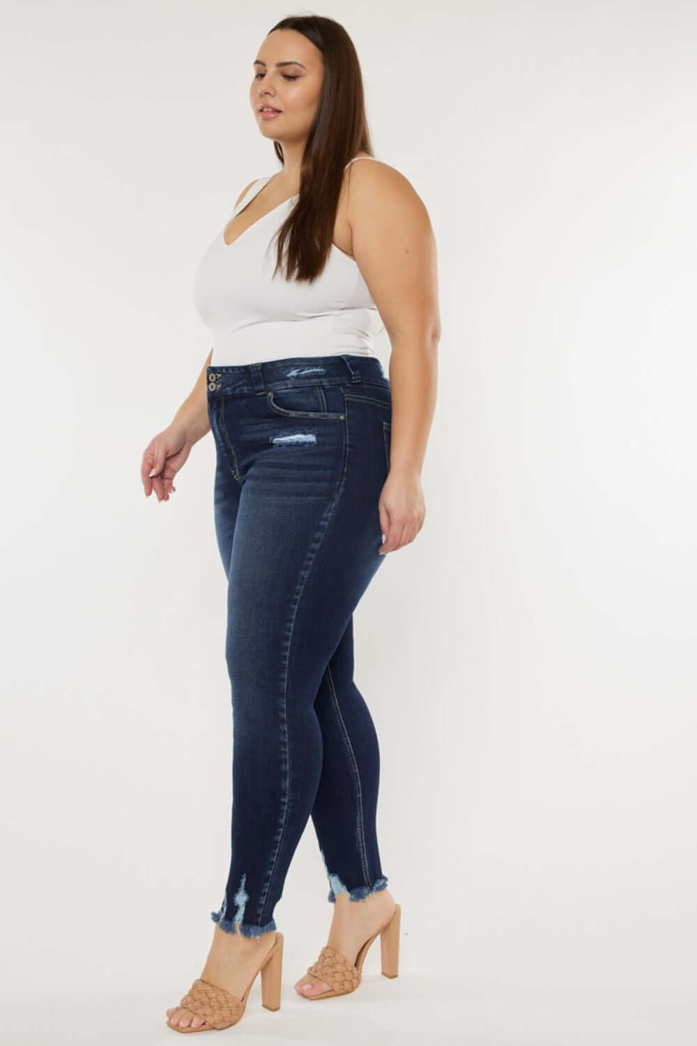 Woman wearing Cat's Whiskers Raw Hem High Waist Jeans, white sleeveless top, and tan heels showcasing vintage-inspired chic look