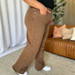 Model wearing RFM Full Size High Rise Garment Dye Wide Leg Jeans in rich brown color, side view showing relaxed fit and high-waist design