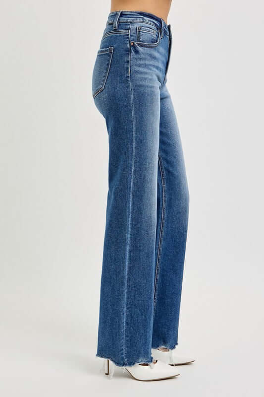 Side view of RISEN Tummy Control High Rise Raw Cut Jeans showcasing stylish high-waisted design and raw hem.