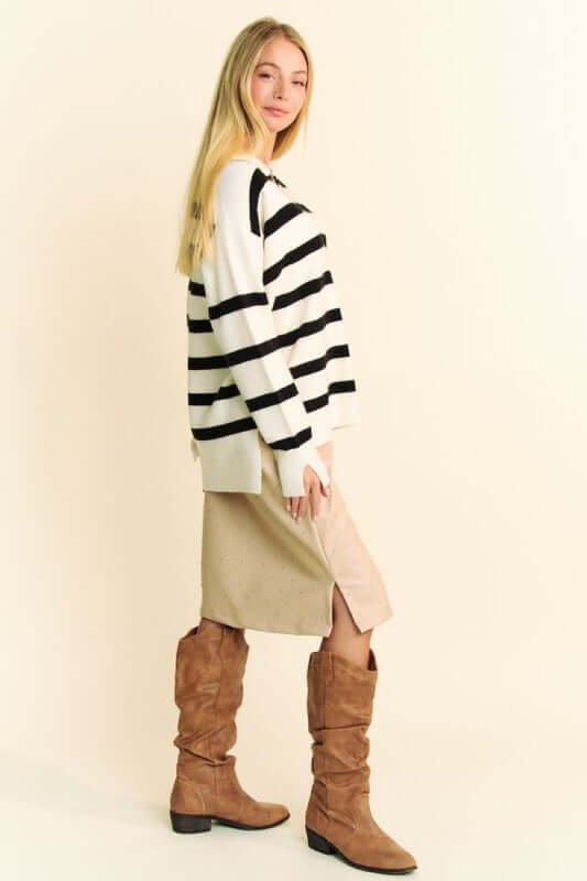 Model showcasing a chic Davi & Dani high-low striped sweater paired with a stylish skirt and knee-high boots.