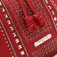 Close-up of Nicole Lee USA Amy Studded Bucket Bag in red vegan leather with zipper and stud detailing.