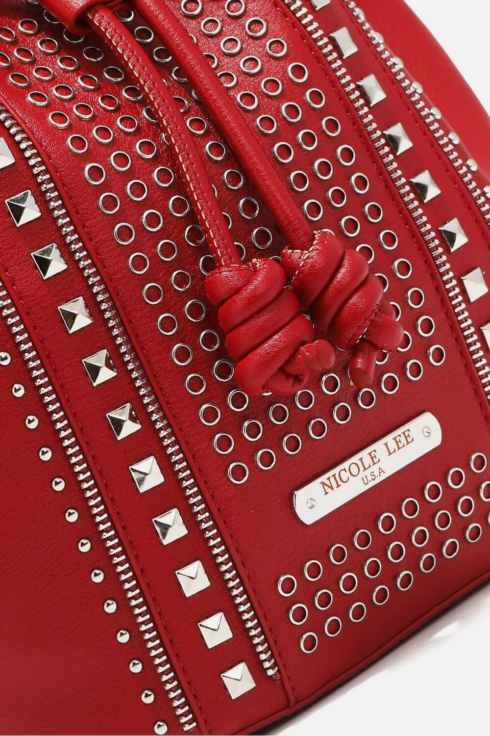 Close-up of Nicole Lee USA Amy Studded Bucket Bag in red vegan leather with zipper and stud detailing.