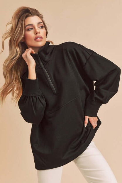 Stylish model showcases a black exposed seam half zip drop shoulder sweatshirt, exuding casual elegance and comfort.