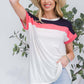 Woman wearing Color Block Round Neck Short Sleeve T-Shirt with red, white, and navy color blocks and jeans while smiling and holding a hat