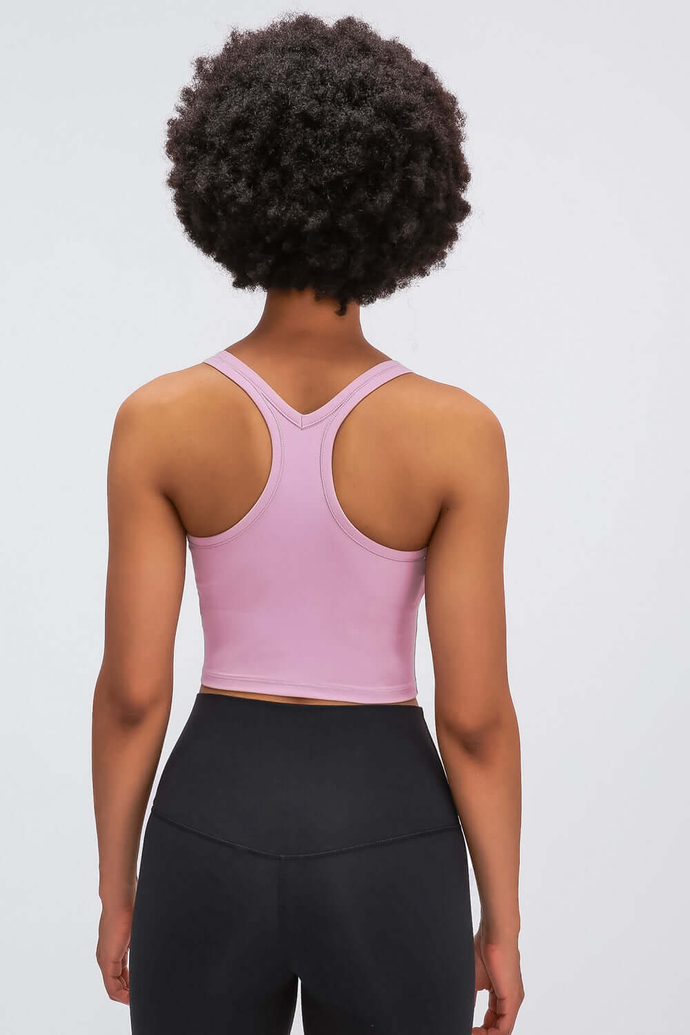 Back view of Millennia Racerback Sports Bra in soft pink, showcasing a sleek, sporty design perfect for yoga and workouts.