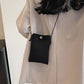 Woman wearing Bella Road Suede Snap Down Crossbody Bag in black with snap-down design and crossbody strap for hands-free convenience.