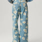 Back view of Bella Road denim floral wide leg jeans, showcasing playful flower pattern and pocket design.