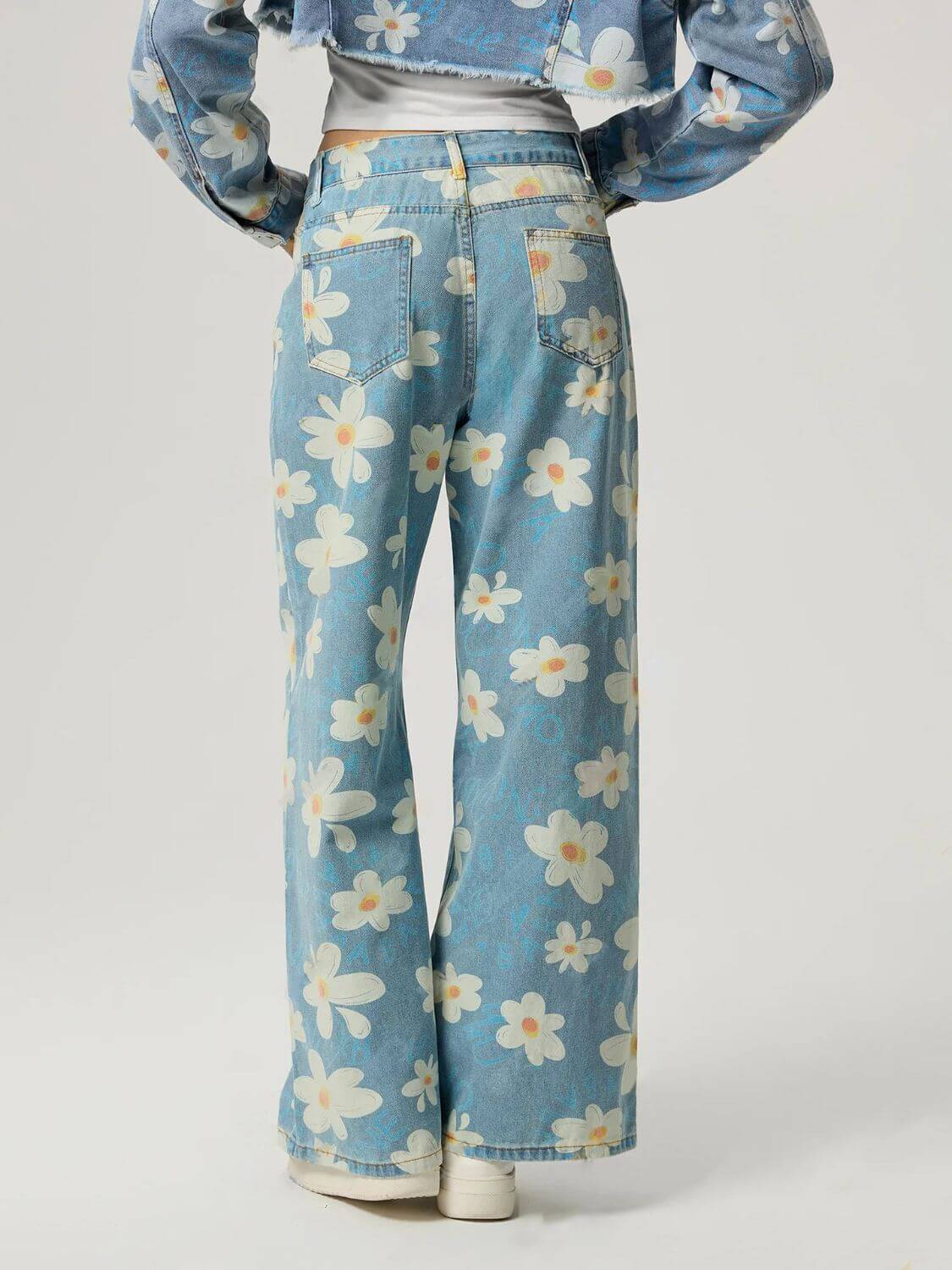 Back view of Bella Road denim floral wide leg jeans, showcasing playful flower pattern and pocket design.