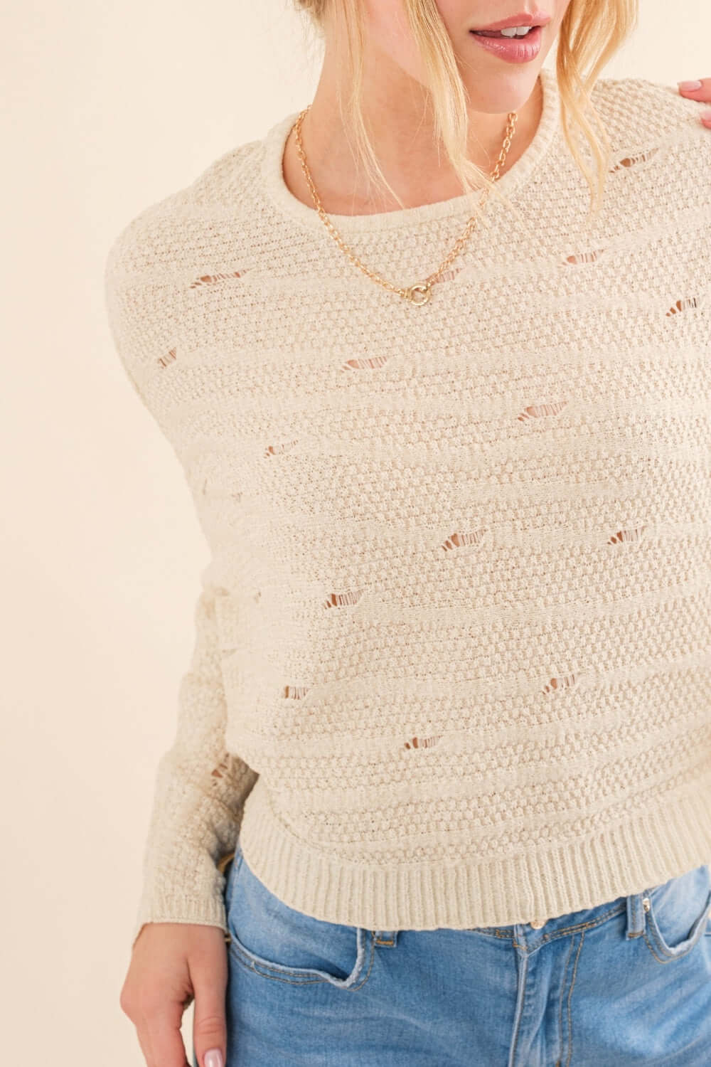 Woman wearing a cozy beige Dolman Sleeves Sweater paired with casual blue jeans