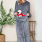 Woman in a cozy gray hooded midi lounge dress with pockets, smiling and holding a plush dog, perfect for fall lounging.