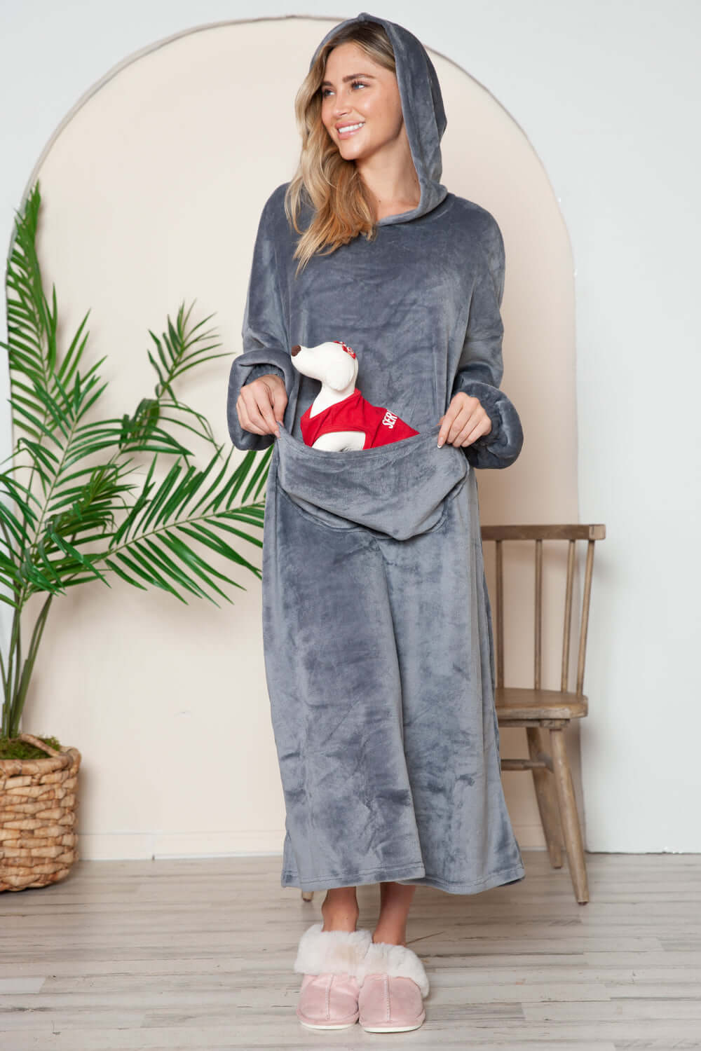 Woman in a cozy gray hooded midi lounge dress with pockets, smiling and holding a plush dog, perfect for fall lounging.