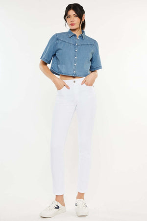 Woman wearing High Rise Ankle Skinny Jeans in white, paired with a blue denim crop top and white sneakers. Perfect for a casual yet stylish look.