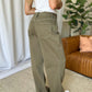 Woman wearing RFM Full Size High Rise Garment Dye Wide Leg Jeans in olive green, showcasing back pockets and wide-leg silhouette.