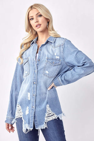 Woman wearing Button Up Distressed Denim Shirt by Risen Jeans, showcasing its casual cool style with distressed detailing.