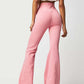 Woman wearing pink asymmetric waist flare jeans showing back view and white top