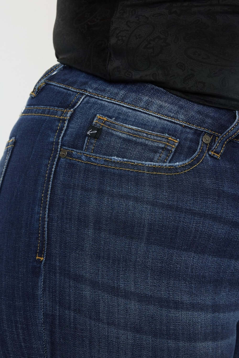 Close-up of Kancan mid-rise slim flare jeans in dark stone wash showcasing stretchy denim and classic zip fly.