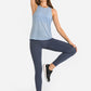 Woman in blue tank top and dark leggings showcasing Millennia High Waist Ankle-Length Yoga Leggings in stylish yoga pose.