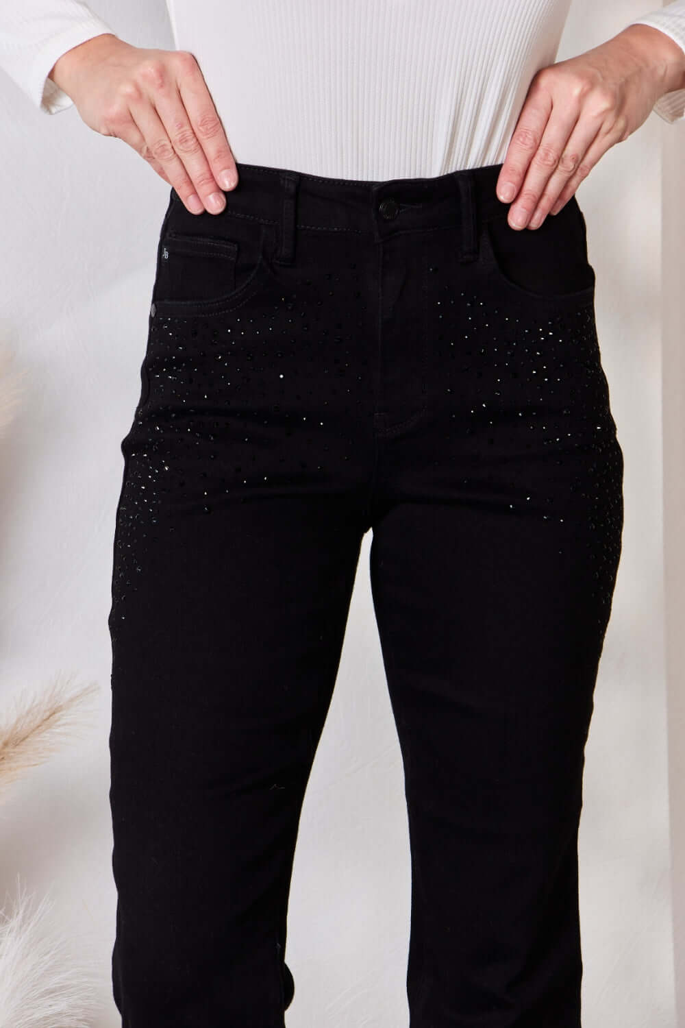 Woman wearing Judy Blue Rhinestone Embellished Slim Jeans with high waist and pocketed design.