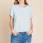 Woman wearing contrast trim short sleeve slit T-shirt in light blue with jeans, showcasing modern and stylish casual wear.