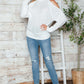 Woman wearing Bella Road cable-knit turtleneck cold shoulder sweater with jeans, perfect for chilly days and a stylish look.