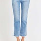 Woman wearing RISEN low rise crop slim straight jeans with raw hem and slight stretch, styled with black sandals.