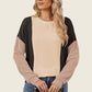 Stylish woman in a Double Take Texture Contrast Round Neck Long Sleeve T-Shirt with sunglasses and a chain strap purse.