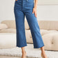 Woman wearing Crop Chloe Full Size Tummy Control High Waist Raw Hem RFM Jeans with a black top and heels