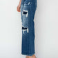 Model wearing high rise patch detailed wide leg crop jeans from Risen Jeans, featuring trendy rips and a modern wide leg silhouette.