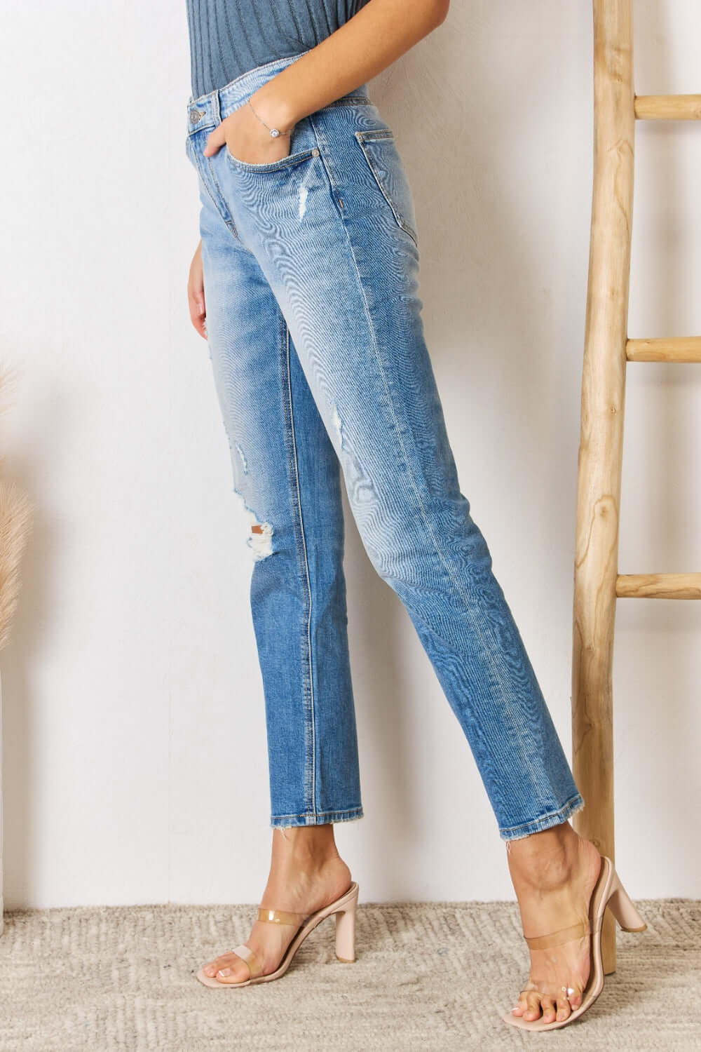 High Rise Distressed Slim Straight Jeans showcasing a flattering silhouette with classic hem and edgy distressed details, perfect for any occasion.