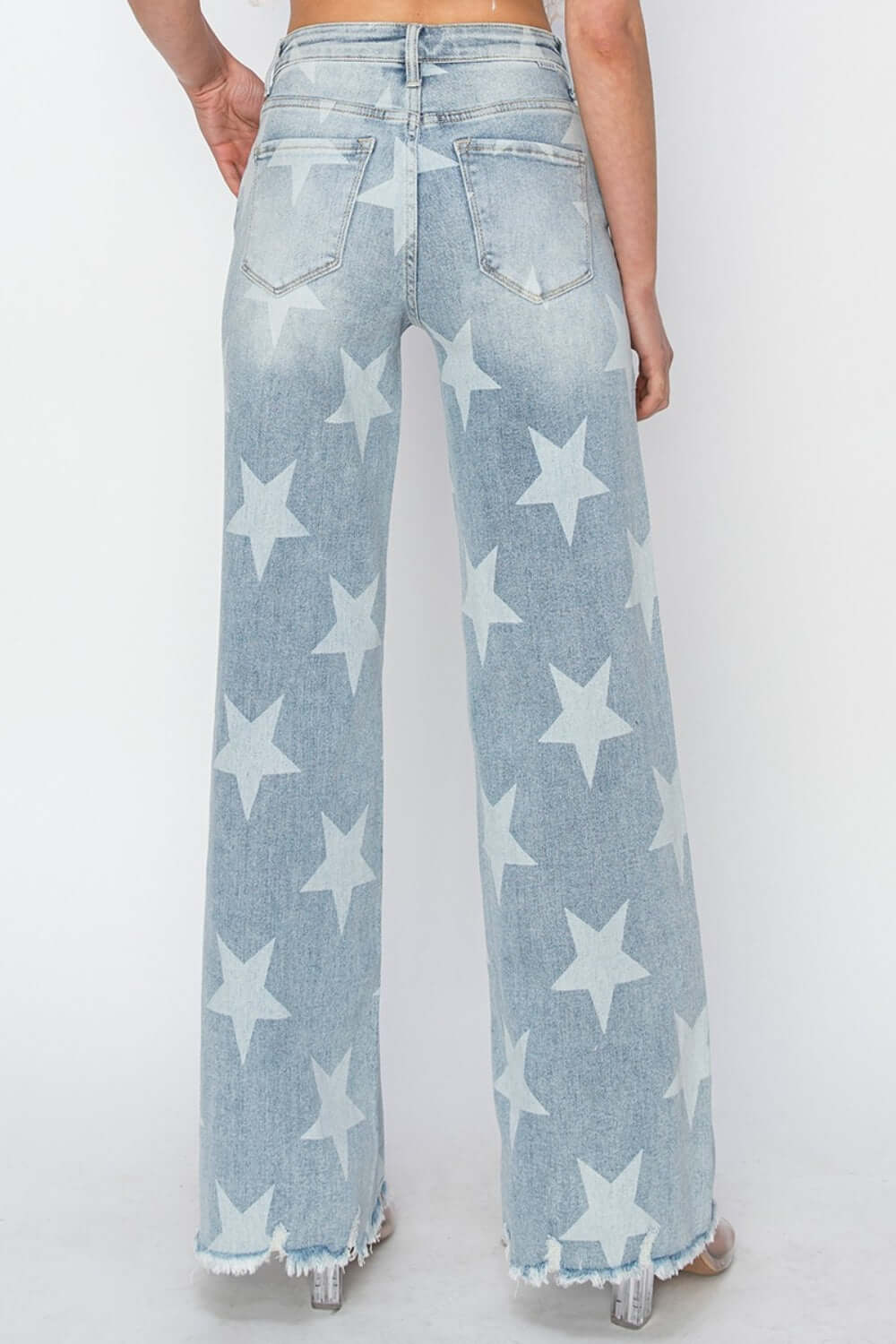 Back view of Risen Jeans full size raw hem star wide leg jeans with star embellishments and an edgy casual vibe.