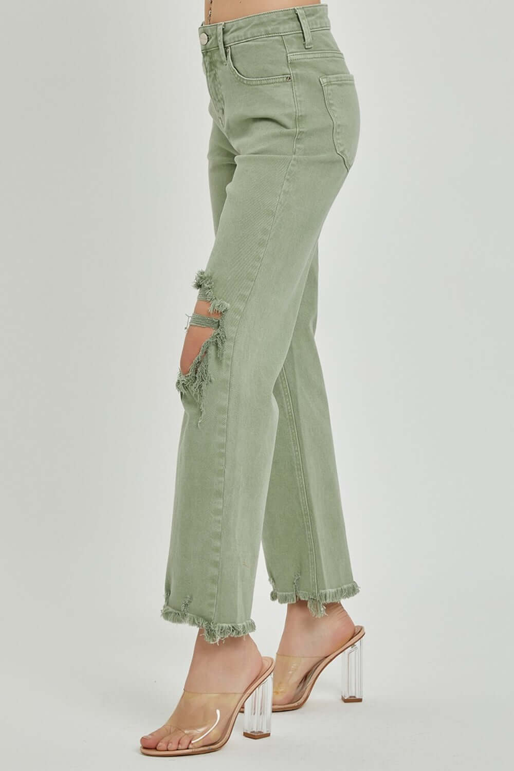 Distressed Ankle Bootcut Jeans in olive with frayed hems and trendy rips by Risen Jeans, paired with clear high-heeled sandals.