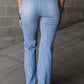 Petite high waist bootcut jeans in light blue denim, rear view, no stretch, pocketed, flattering fit for curves.