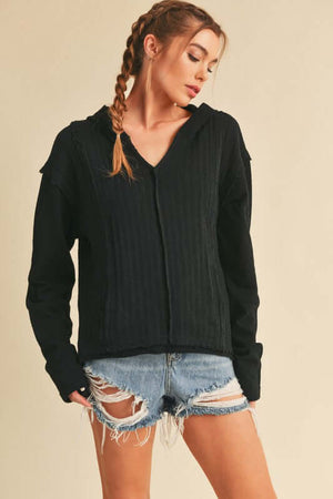 Aemi + Co frayed hem long sleeve hoodie styled with distressed denim shorts on a model.