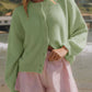 Model wearing a mint green Bella Road button down cardigan over striped shorts by the beach. Perfect for cozy days!