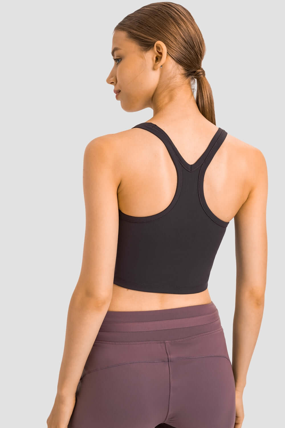 Stylish back view of Millennia Racerback Sports Bra in black, perfect for yoga and workouts with removable padding.