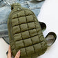 Olive green Bella Road Quilted Nylon Crossbody Bag on denim jacket, ideal lightweight travel accessory in puffy quilted design.