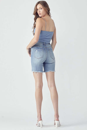 High Rise Distressed Denim Shorts by Risen Jeans with raw hem and pocketed design, modeled from behind.