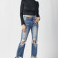 Woman wearing high waist distressed frayed hem cropped straight Risen Jeans styled with black heels and a fitted black top.