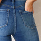 Woman wearing Kancan High Rise Raw Hem Flare Jeans showcasing back pockets and flattering high-rise design.