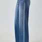 High waist wide leg Risen jeans in blue denim paired with heels for a chic and trendy look