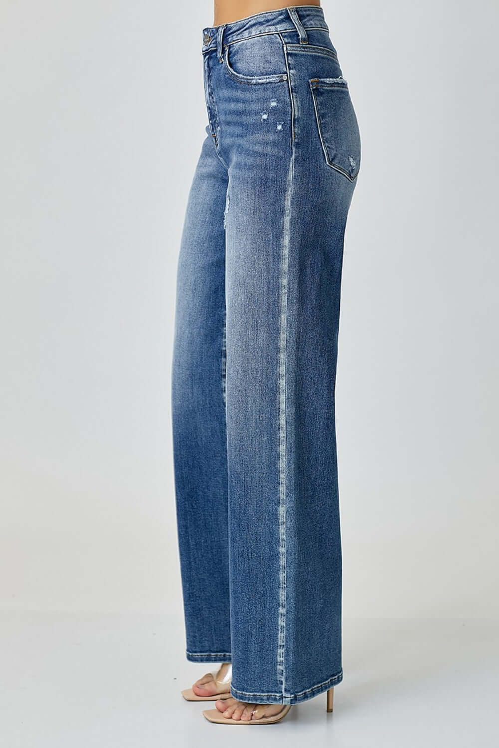 High waist wide leg Risen jeans in blue denim paired with heels for a chic and trendy look