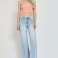 Woman wearing RISEN Full Size Wide Leg V Dipped Front Waist Jeans and peach tube top, showcasing modern and flattering jean style