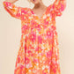 Woman wearing a vibrant orange and pink floral printed dress with puffy sleeves and a V-neckline.